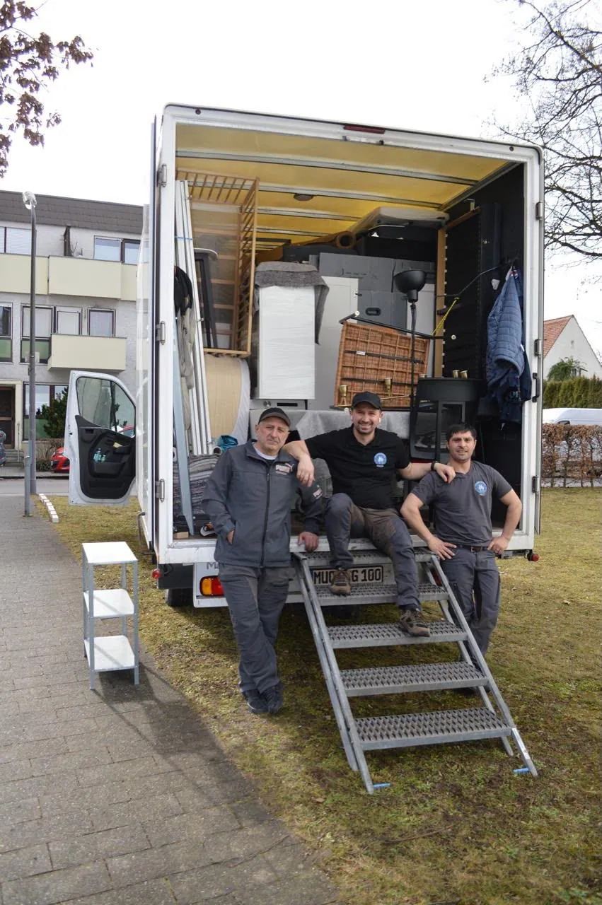 Team vor einem beladenen Umzugsfahrzeug bei Umzug und Entrümpelung