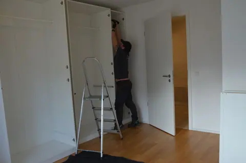 Mitarbeiter montiert einen Schrank